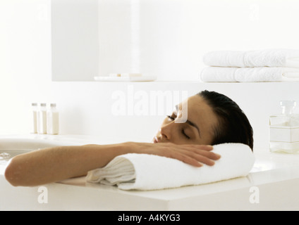 Donna in bagno di testa di appoggio sul bordo della vasca Foto Stock