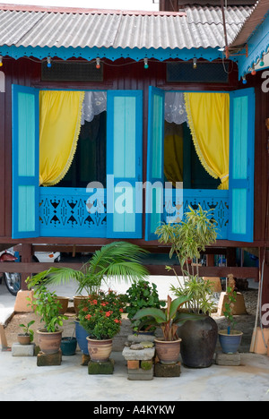 Dipinto luminosamente windows di una tipica casa malese in una città interna kampong Kampung Morten in Malacca Foto Stock