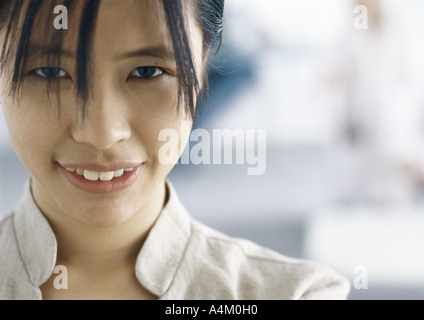 Giovane donna sorridente in telecamera, close-up Foto Stock