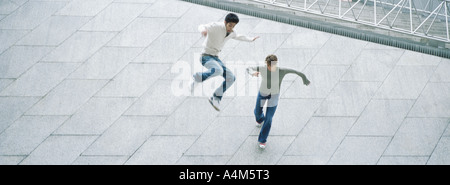 Coppia giovane correre, saltare, ad alto angolo di visione Foto Stock