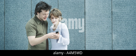 Coppia giovane guardando il telefono con fotocamera Foto Stock