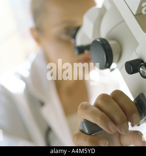 Medico guardando attraverso il microscopio Foto Stock