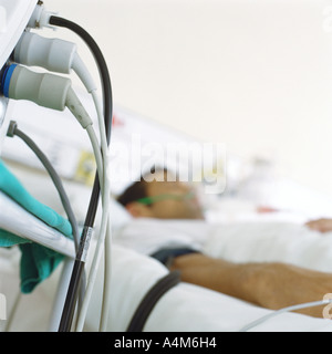 Paziente nel letto di ospedale e i fili provenienti dal monitor Foto Stock