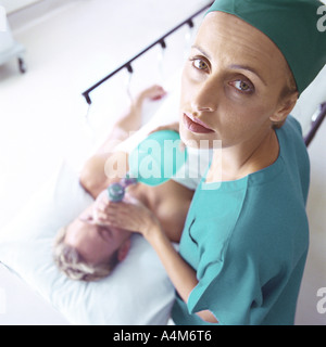 Medico donna tenendo le maschere di ossigeno oltre il viso del paziente, ad alto angolo di visione Foto Stock