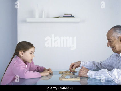 Nonno e nipotina gioca domino insieme Foto Stock