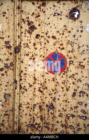 Nessun parcheggio / Nessun arresto segno dipinto sul danneggiato porta di metallo. Mostar, Bosnia Erzegovina Foto Stock