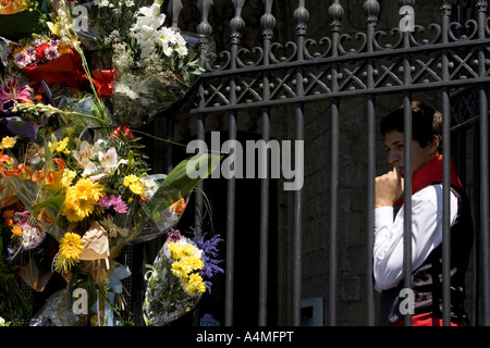 Giovane uomo nel profondo pensiero accanto a omaggi floreali, chiesa di San Miguel, Fiesta de la Virgen Blanca, Vitoria-Gasteiz Foto Stock