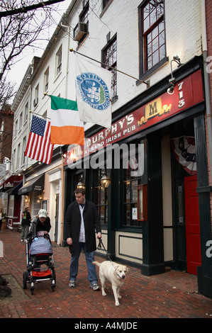 Giovane passeggiate sul marciapiede di mattoni nella parte anteriore del Murphy's Grand Pub Irlandese su King Street nella Città Vecchia di Alexandria VA Foto Stock