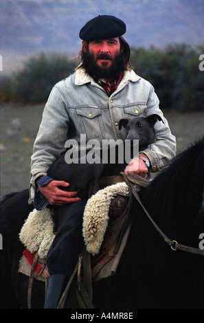 Un turista s guide gaucho a cavallo con il suo cane in El Calafate Argentina Foto Stock