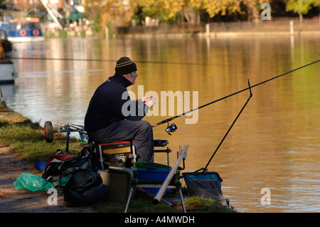 Un pescatore sul lato dell'Isis,il Thames in Oxford su un luminoso giorno inverni.partecipare nel corso di una competizione di pesca Foto Stock