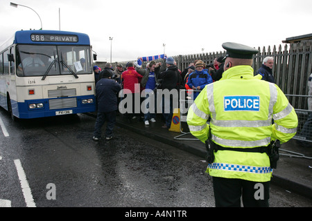 PSNI poliziotto in hi vis orologi giacca ulster autobus pieno di sostenitori linfield essendo cercato dalla sicurezza del gioco in zona cattolica Foto Stock