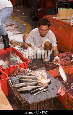 Borneo malese Sarawak Kuching domenica mercato l'uomo preparare pesce Foto Stock