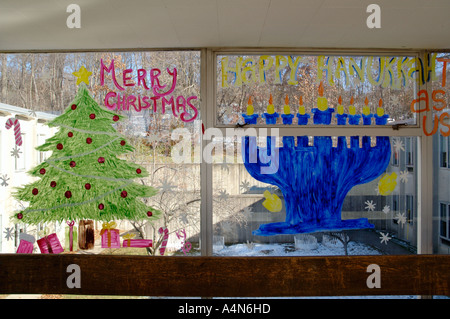 I saluti delle vacanze dipinti per Natale e hanukkah sulla scuola pubblica le finestre del corridoio Foto Stock