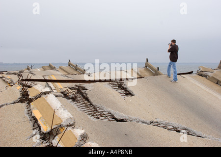 Adolescente maschio in piedi sui resti del ponte di tiro che collega Ocean Springs a Biloxi, Mississippi, oltre la Back Bay dopo l'uragano Katrina Foto Stock