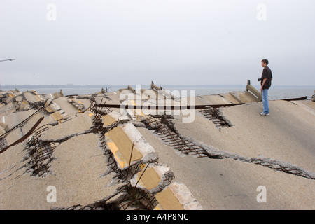 Adolescente maschio in piedi sui resti del ponte di tiro che collega Ocean Springs a Biloxi, Mississippi, oltre la Back Bay dopo l'uragano Katrina Foto Stock