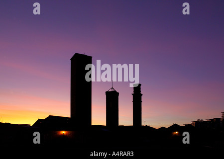 Tramonto dietro i tre camini delle opere della torre, Globe Road Leeds West Yorkshire Regno Unito Foto Stock