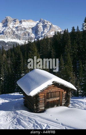 Cabina di legno nella foresta e le montagne del Dolamites in inverno la neve , Italia Foto Stock