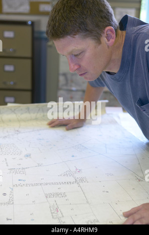 L uomo lo studio di una mappa dettagliata della sua area locale Foto Stock