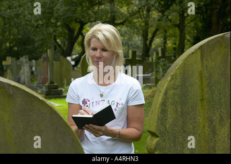 Signora guardando i dettagli su una lastra tombale Foto Stock