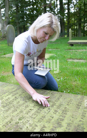 Signora guardando i dettagli su una lastra tombale Foto Stock