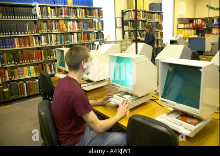 Giovane uomo studiando gli archivi di microfilm presso la locale county records office Lancashire England Regno Unito Foto Stock