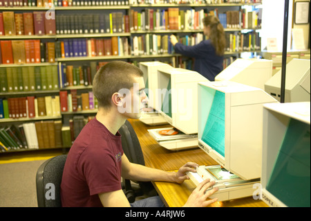 Giovane uomo studiando gli archivi di microfilm presso la locale county records office Lancashire England Regno Unito Foto Stock