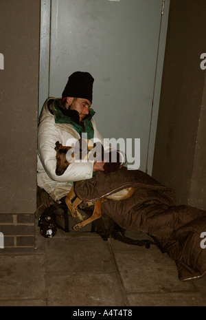 Senzatetto uomo con il suo cane addormentato in porta. Foto Stock