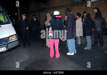 La gente in attesa di polizia per raccogliere i loro beni dalle case dopo essere stati sfrattati da sant Agnese posto Squat nel sud di Londra. Foto Stock
