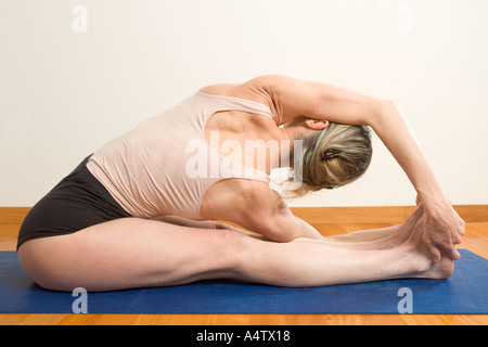 Una donna pratica Parivrtta Paschimottanasana nove posture yoga Iyengar Yoga style Foto Stock