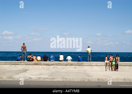 Un gruppo di giovani lungo la parete di El Malecon, Havana, Cuba Foto Stock