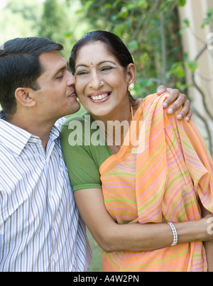 Uomo di baciare la sua madre sulla guancia all'aperto Foto Stock