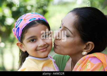 Donna baciando la sua nipote sulla guancia all'aperto Foto Stock