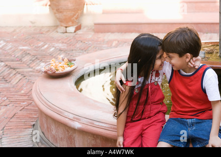 Bambini costeggiata da fontana all'aperto Foto Stock