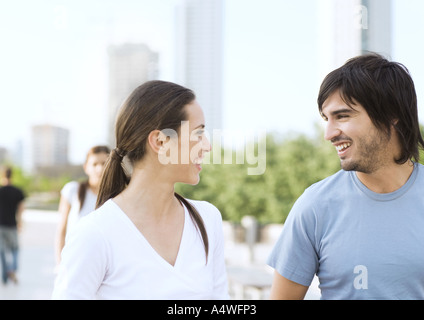 Coppia giovane sorridente ad ogni altro nel parco urbano Foto Stock