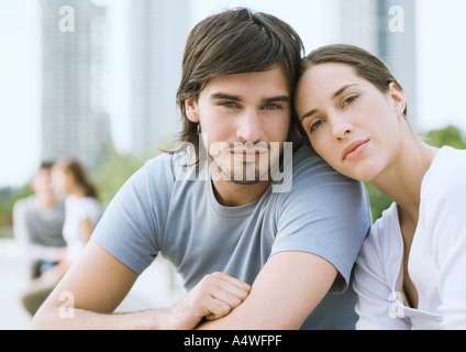 Coppia giovane nel parco urbano, donna appoggiato la testa sull'uomo spalla Foto Stock