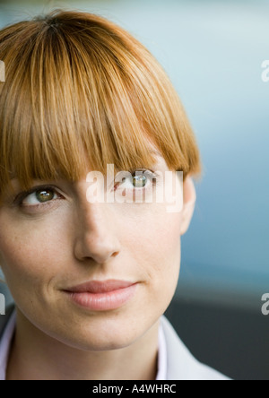Donna con bangs guardando in alto, ritratto Foto Stock
