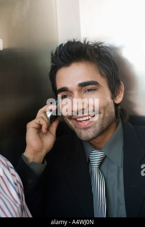 Imprenditore parlando al cellulare in ascensore Foto Stock