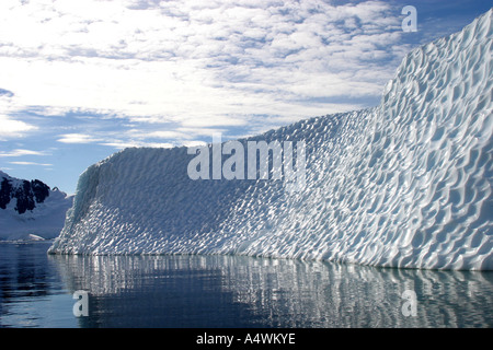 Splendidamente scolpito iceberg in Antartide con riflessioni nel mare calmo Foto Stock