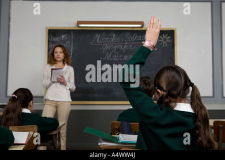 Giovane studente alzando la mano in classe Foto Stock