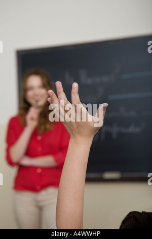 Studente con mano sollevata in classe Foto Stock