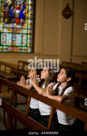 I giovani studenti in preghiera nella chiesa Foto Stock