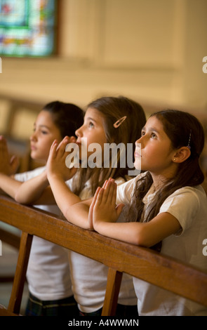 I giovani studenti in preghiera nella chiesa Foto Stock