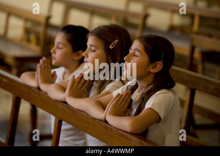 I giovani studenti in preghiera nella chiesa Foto Stock