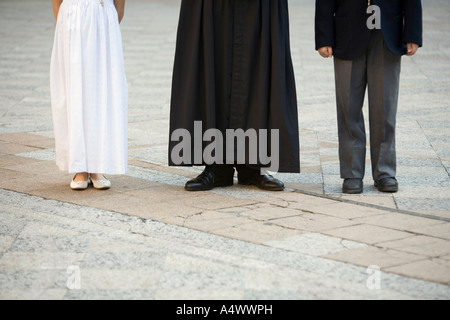 Derubato sacerdote con formalmente vestiti bambini Foto Stock