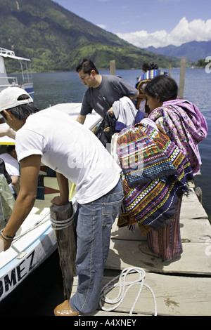 GUATEMALA Santiago Atitlan indigeni Tzutujil Maya le donne nei tradizionali intrecciato trajes attendere per vendere i loro tessuti Foto Stock