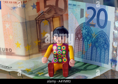 Tra banconote diverse figure (Playmobil) stand. 20, 50 euro. Foto Stock