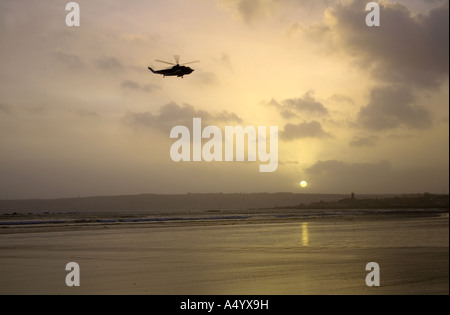 Penzance al tramonto dalla roccia lungo la Cornovaglia con British International elicottero sorvolano Foto Stock