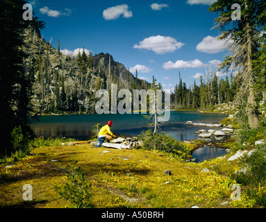 Escursionista si prende una pausa su un lago nel paese alto della Sawtooth National Recreation Area di Idaho Foto Stock