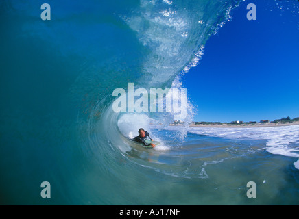 Un surfista in una perfetta onda cava, scattato dall'interno della canna. Foto Stock