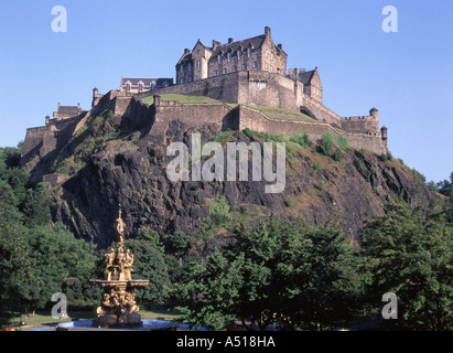 Iconico punto di riferimento e il famoso storico edificio fortezza il castello di Edimburgo sulla affioramento di granito domina lo skyline della città parte della Fontana nel parco sottostante la Scozia Foto Stock